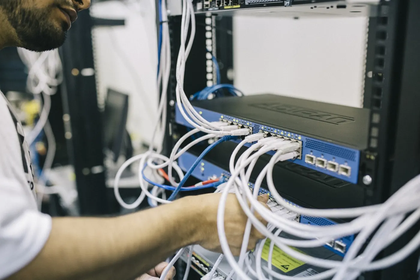 Técnico conectando cables en un rack de comunicaciones